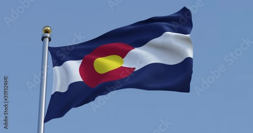  Colorado flag blowing in the wind in front of a blue sky