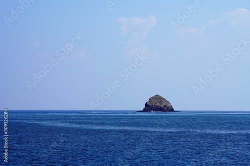small rock island in azure sea © Morten H