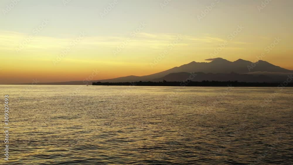 sunset over the ocean and island with mountain, Golden horizon and calm sea landscape