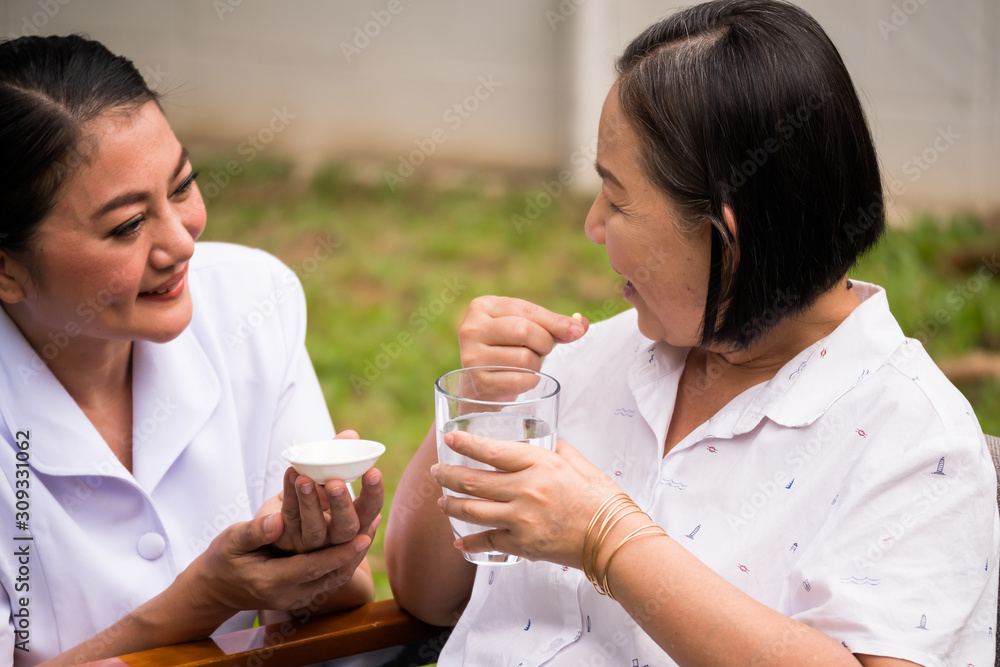 nurse taking a pills to female patient at the hospital park