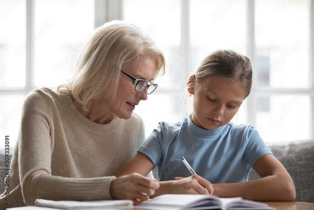 Loving grandmother help granddaughter with school assignment Loving grandmother help granddaughter with school assignment