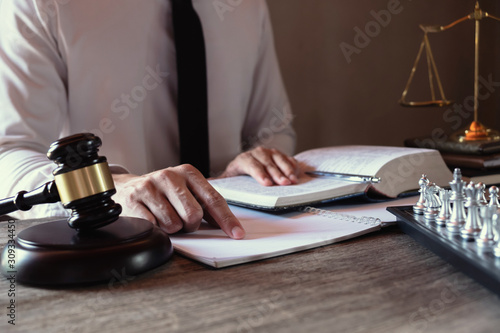 Male lawyer working with lawsuit papers on table in courtroom