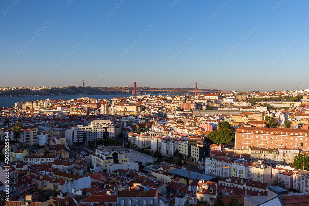 Panoramic city view from above of the downtown, 25 de Abril Bridge (Ponte 25 de Abril, 25th of April Bridge) over Tagus River and beyond in Lisbon, Portugal.