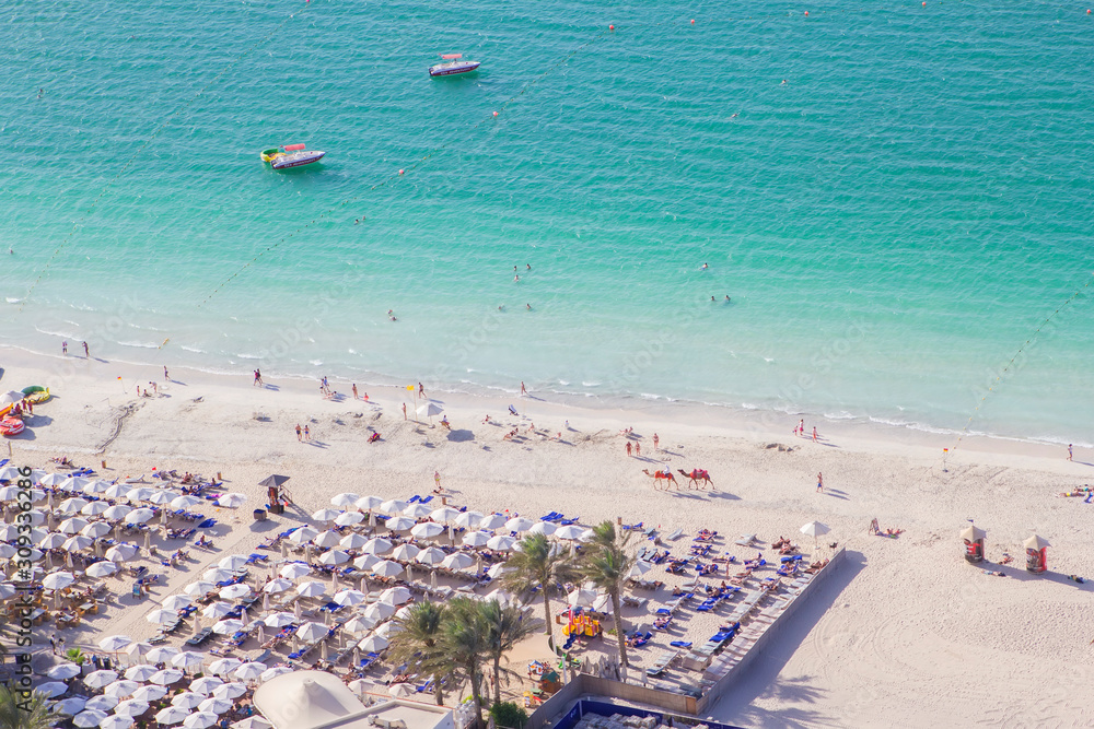 background top view of the beautiful snow-white beach and the emerald water of the Persian Gulf in Dubai Marina, Dubai, UAE background top view of the beautiful snow-white beach and the emerald water of the Persian Gulf in Dubai Marina, Dubai, UAE