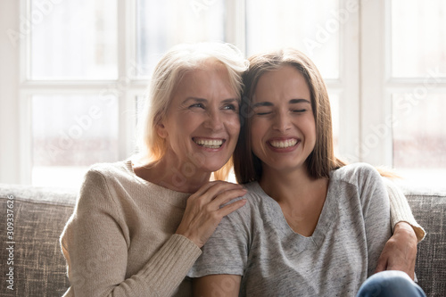 Happy senior mom and adult daughter have fun at home photo