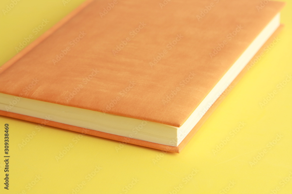 Fototapeta premium book with orange cover on colorful background