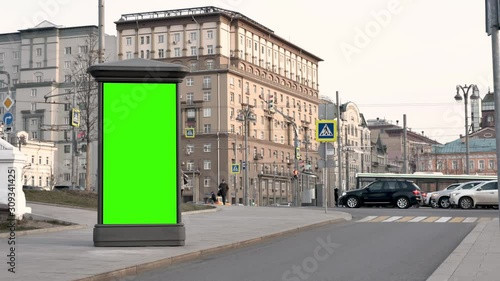 Wallpaper Mural Winter day. City street. A showcase with a green screen stands against the backdrop of large beautiful buildings. At the traffic lights are cars. Passers-by are coming. Torontodigital.ca