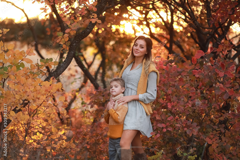mother and son walk together in the Park in autumn in warm clothes. mother and son walk together in the Park in autumn in warm clothes.