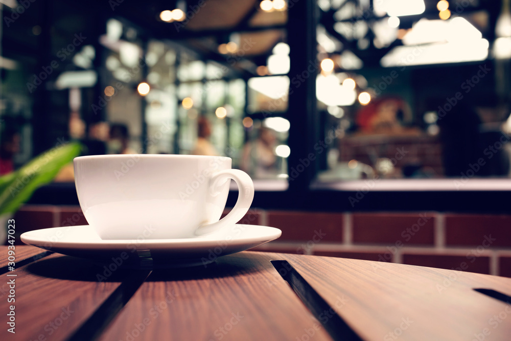 Coffee cup on wood table in coffee shop.