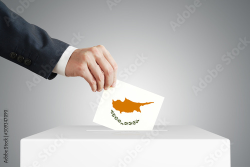 Man putting a ballot into a voting box. photo