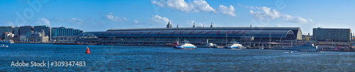 panoramic view of central station in amsterdam from side of the water, cityscape