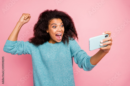 Photo of grimacing crazy excited overjoyed woman screaming in having completed level in game isolated pink pastel color background photo