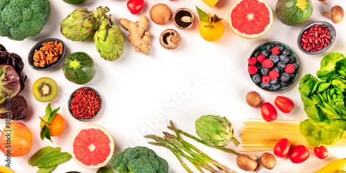 Vegan food panorama with copy space. Healthy diet concept. Fruits, vegetables, pasta, nuts, legumes, mushrooms, shot from above on a white background, forming a frame with a place for text. A flatlay