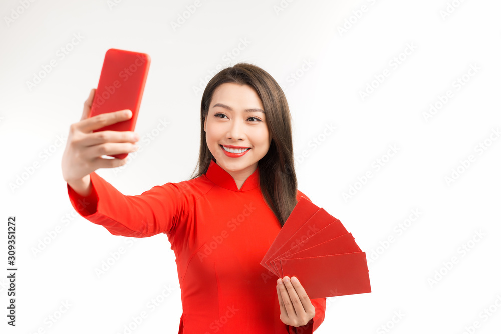 Beautiful asian women in ao dai showing angpao and selfie with phone on white background, Beautiful asian women in ao dai showing angpao and selfie with phone on white background,