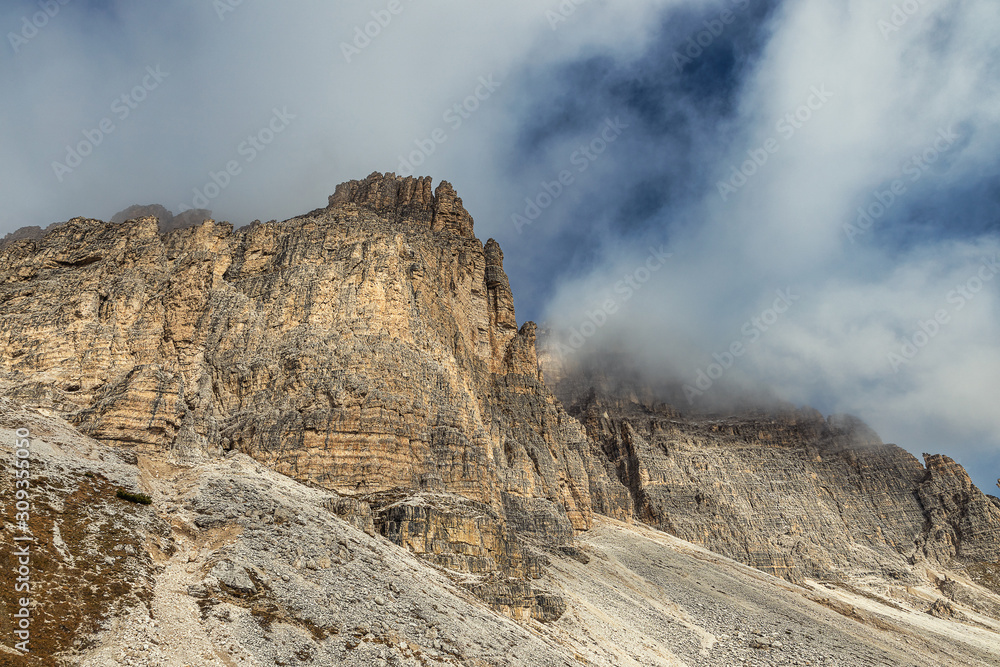 Rocky mountains and cloudy blue sky in Tre Cime di Lavaredo national park, Dolomites, Italy