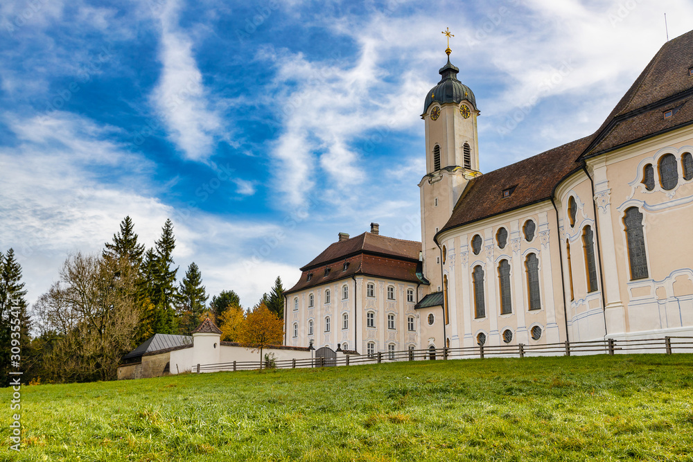 Pilgrimage Church Wieskirche with clody blue sky and green lawn  in Bavaria, Germany.