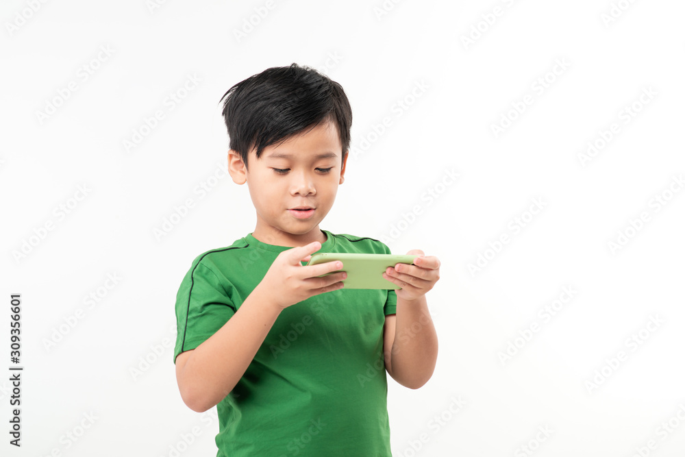 Clever kid is playing with green smart cell phone isolated on white background Clever kid is playing with green smart cell phone isolated on white background