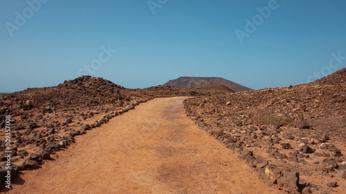 Empty path through the rough and arid landscape of Lobos Island, known locally as Isla de Lobos, a largely uninhabited islet located north of the island of Fuerteventura, Canary Islands, Spain