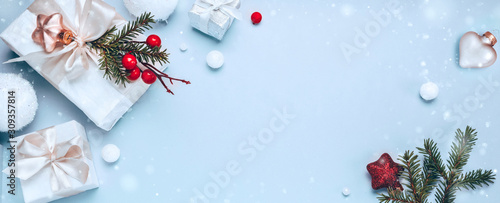 Christmas holiday composition, white gift boxes and golden Christmas toys on a light blue background. Minimalism, flat lay. Copy space