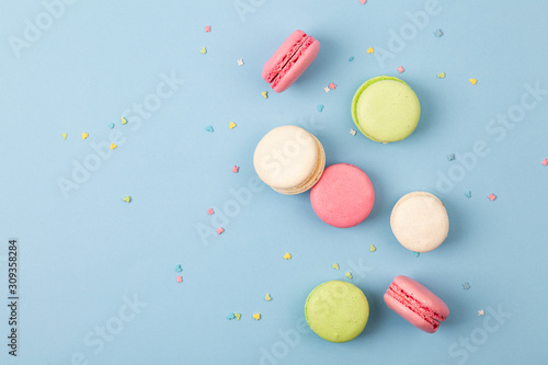Cake macaron or macaroon on blue background, colorful almond cookies. French almond cookies on dessert top view. photo