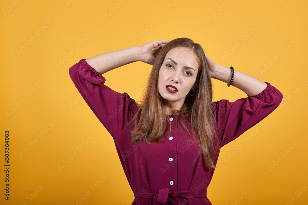 Ginger girl over isolated orange background in burgundy bluse frustrated holding hands on head Ginger girl over isolated orange background in burgundy bluse frustrated holding hands on head