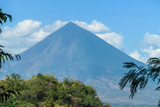 A distant view on Volcano Inierie, Bajawa, Indonesia. The pyramid like mountain towers above the landline. There are no other high volcanos around. The upper slopes are bare without any vegetation.