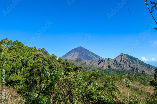 A distant view on Volcano Inierie  Bajawa  Indonesia. The pyramid like mountain towers above the landline. There are no other high volcanos around. The upper slopes are bare without any vegetation.
