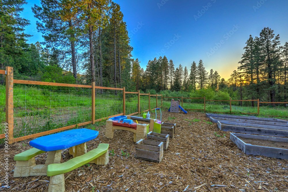 Large fenced in garden with kids play ground area and raised beds. Large fenced in garden with kids play ground area and raised beds.