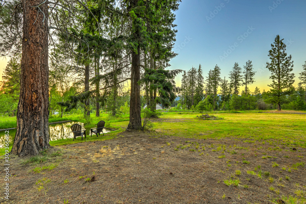 Obraz premium Summer mountain home large property with water canal and pond.
