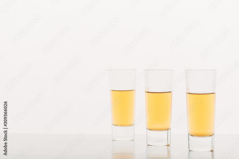 three shots with alcohol in row isolated on white three shots with alcohol in row isolated on white