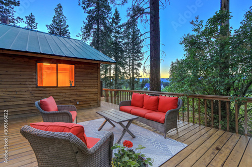 Luxury summer evening mountain home eteriors with cozy porch fire table and new furniture design.