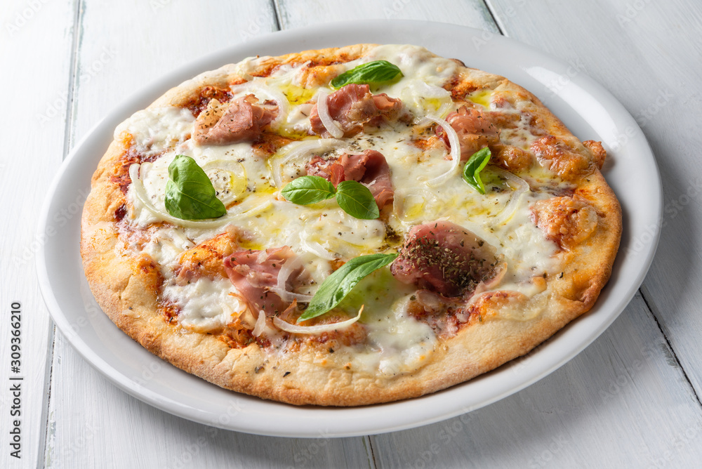 Pizza con prosciutto cotto, scaglie di grana, cipolla, mozzarella, pomodoro, origano e basilico fresco Pizza con prosciutto cotto, scaglie di grana, cipolla, mozzarella, pomodoro, origano e basilico fresco