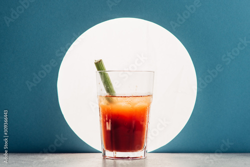 bloody Mary with celery on blue background with back light