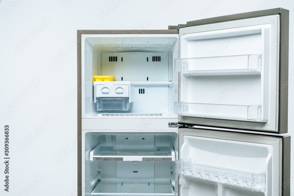 Fototapeta premium empty open fridge and freezer isolated on white