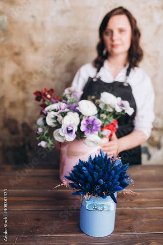 Woman florits brunette makes bouquets in her studio. Industry, professional, florsitika photo