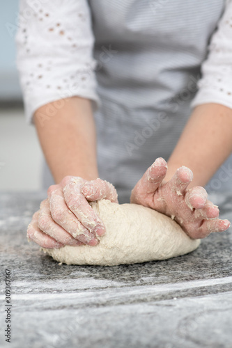 Woman`s hands making dough in the kitchen at home