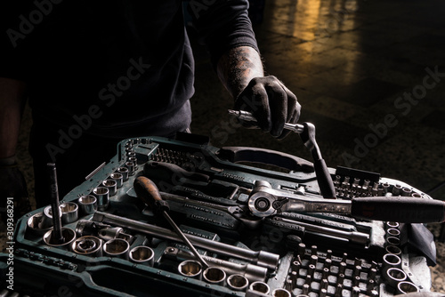 Obraz na płótnie Detail of the hands of a mechanic taking a screwdriver from a toolbox w salonie