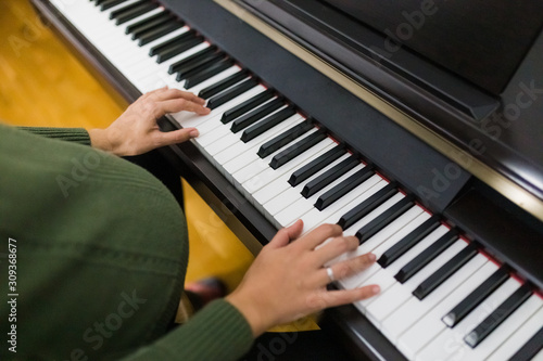 Young pregnant woman sitting at the piano.