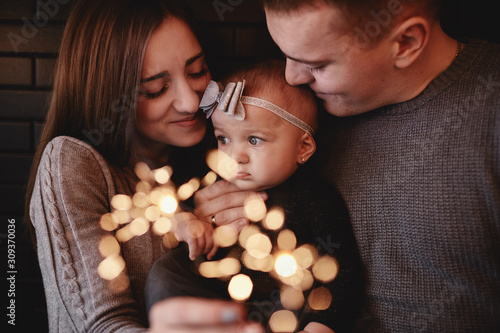 Photography portrait of happy family, mom, dad and baby girl with sparklers in front