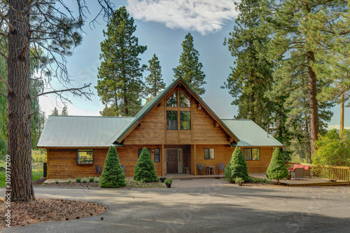 Luxury Cedar cabin front entrance home with Large pine tree and pond