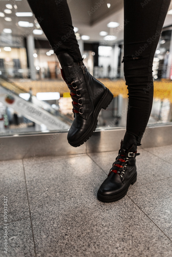 håndtag undulate Fordampe Trendy brutal leather black boots with red shoelaces on female legs.  Close-up. Autumn-winter footwear. New youth fashionable collection of  seasonal shoes. Stock-foto | Adobe Stock