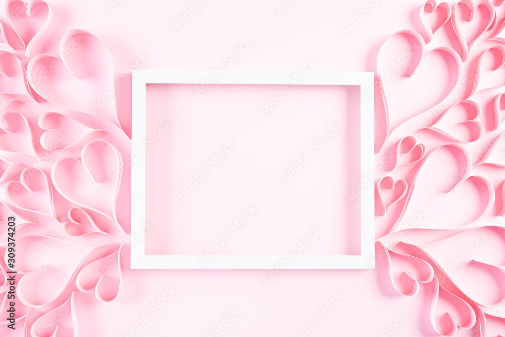 Pink paper hearts with white picture frame on Light pink pastel paper background. Love and Valentine's day concept.