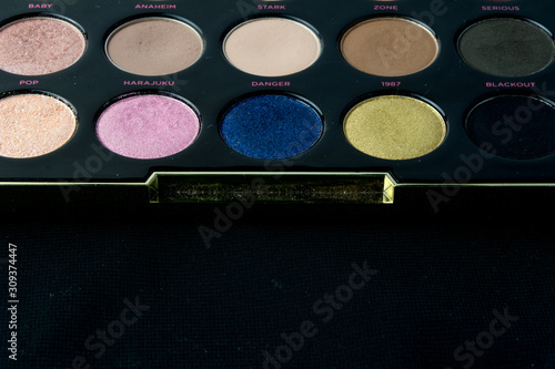 Make-up colorful eyeshadow palettes isolated on black background. View from above.  photo