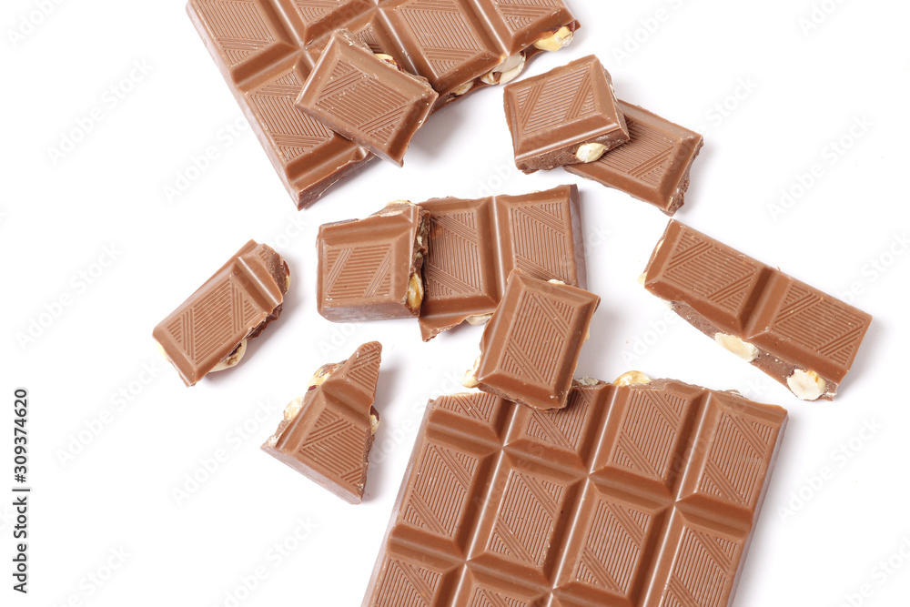 A bar and pieces of milk chocolate isolated on a white background. top view