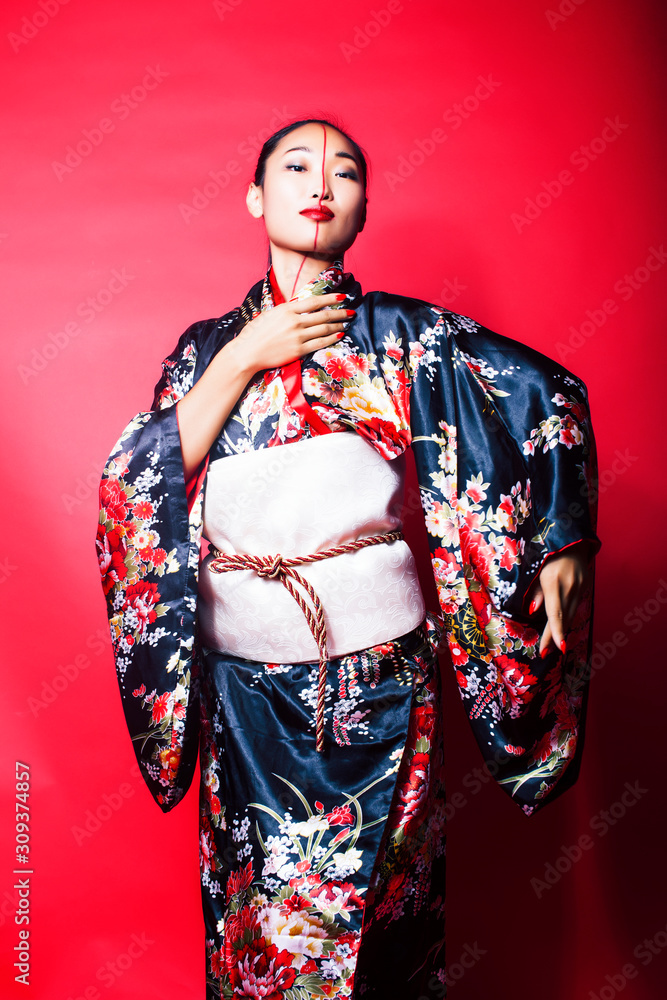 young pretty geisha on red background posing in kimono, oriental concept young pretty geisha on red background posing in kimono, oriental concept