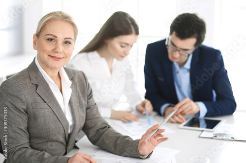 Wallpaper Mural Headshot of business woman at negotiation. Group of business people discussing questions at meeting in modern office. Teamwork, partnership and business concept Torontodigital.ca