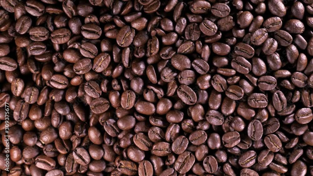 Roasted coffee bean. Fragrant coffee beans scrolls slowly around the camera. Slow Motion Close Up of Whole Roasted Coffee Beans. Roasted coffee bean. Fragrant coffee beans scrolls slowly around the camera. Slow Motion Close Up of Whole Roasted Coffee Beans.