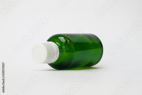 Green color small pharma grade empty glass bottle with white cap. High Resolution. Mock up