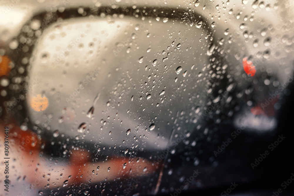 Blurred rain drop on the car glass background, water drops at the car window driver side. Blurred rain drop on the car glass background, water drops at the car window driver side.
