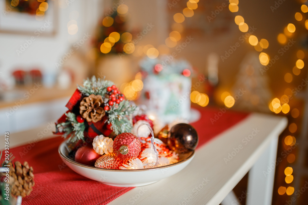 Beautiful holiday decorated kitchen with Christmas tree and bright lights , holiday glasses on the main plan, blur background